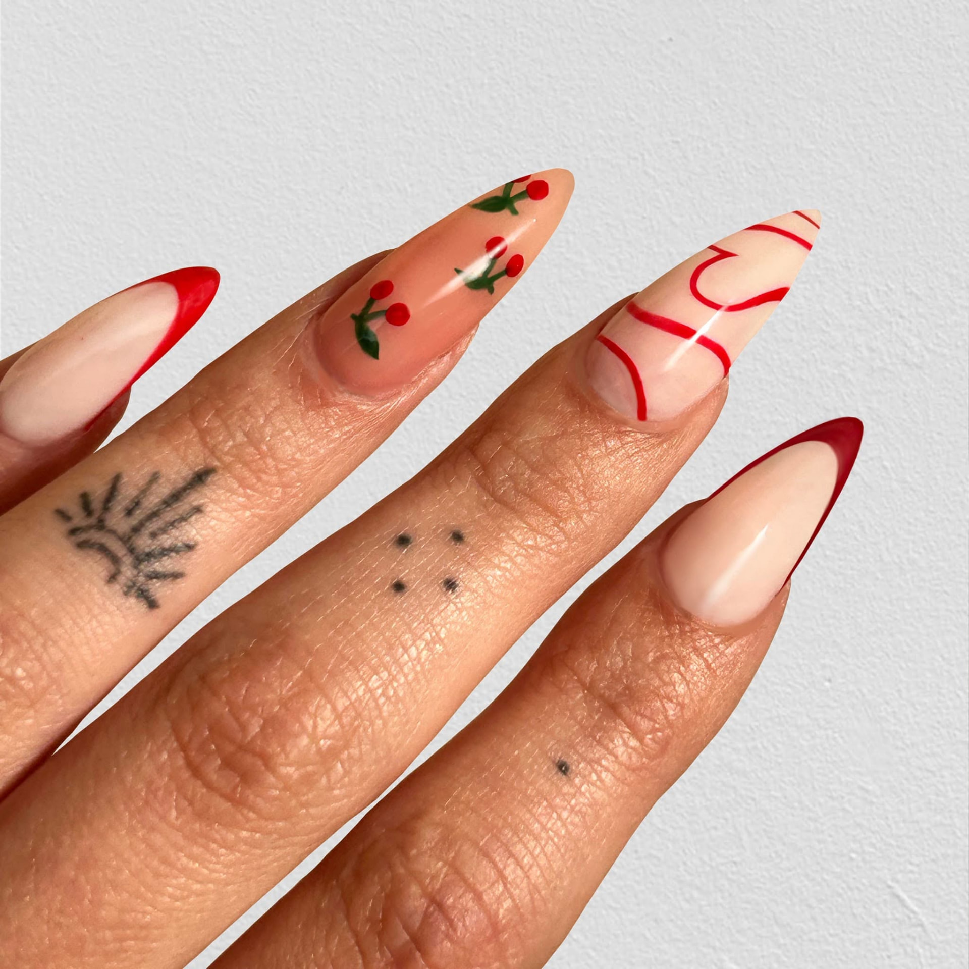 Intricate red folk and astrological nail motifs